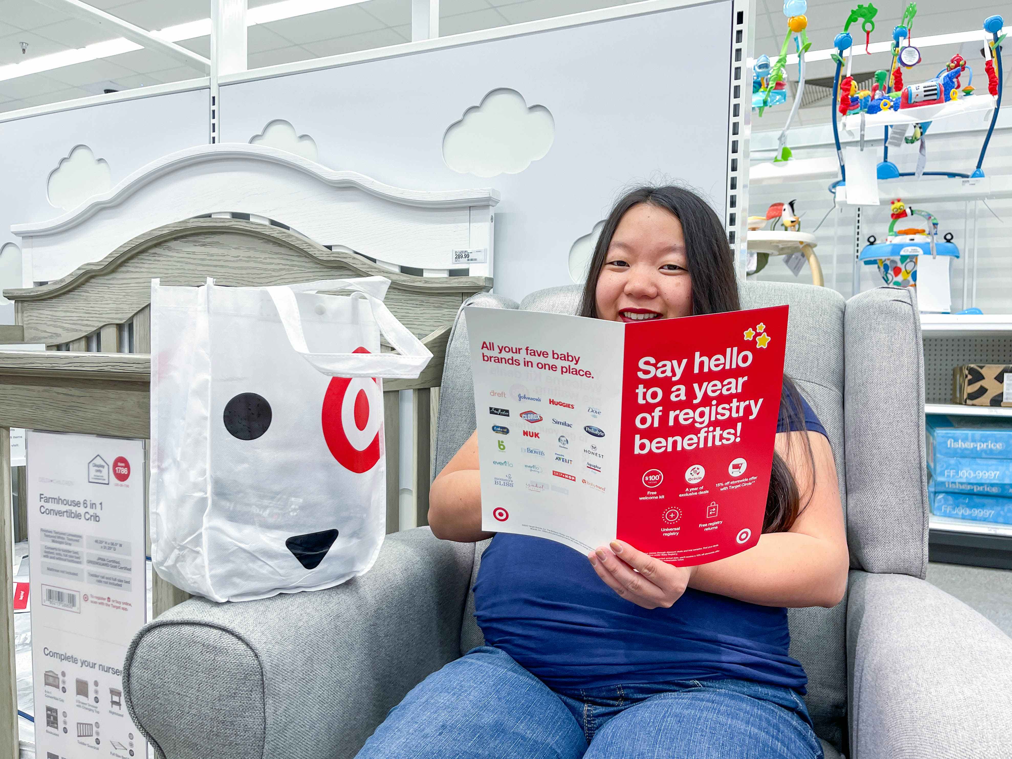 a woman sitting down with a target baby registry welcome bag and brochure