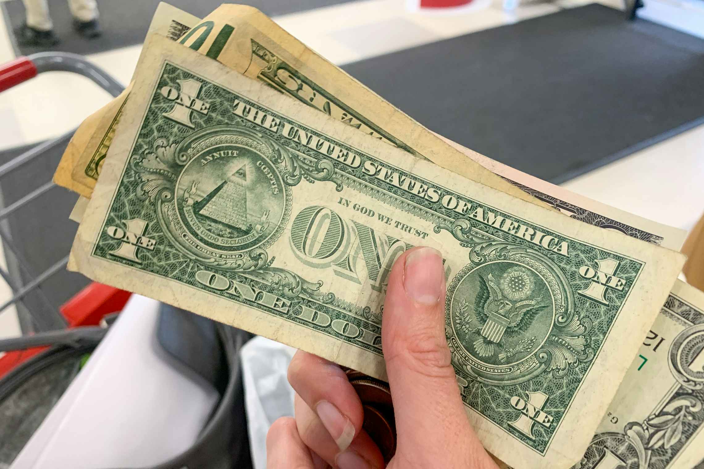 Person holding cash and change from a return at TJ Maxx