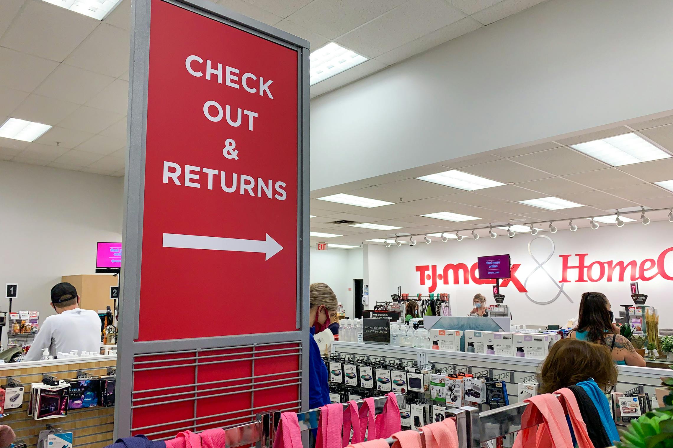 Check out and T.J.Maxx returns sign with people standing in line