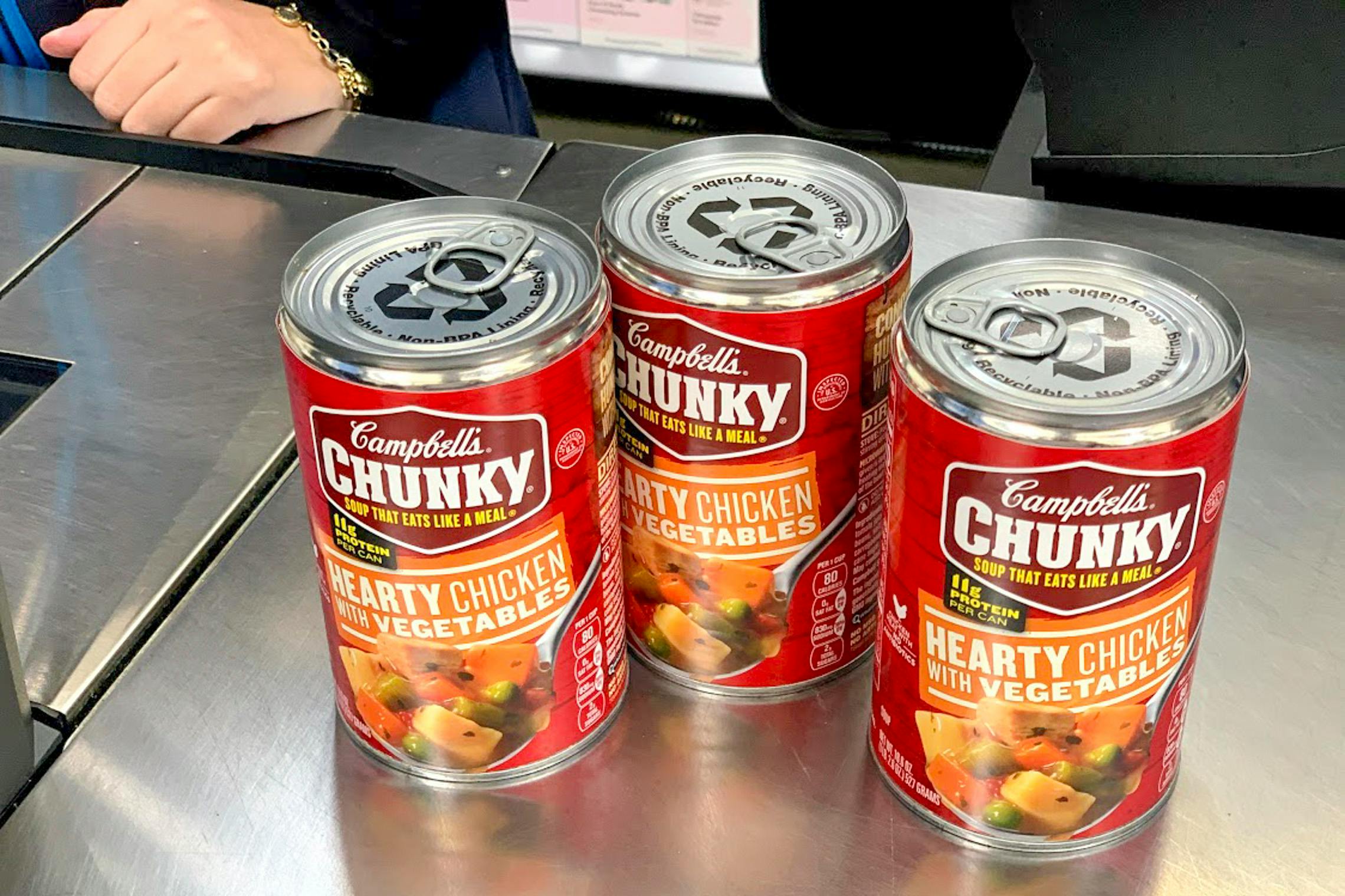 Three cans of chicken vegetable stew on the return counter at walmart
