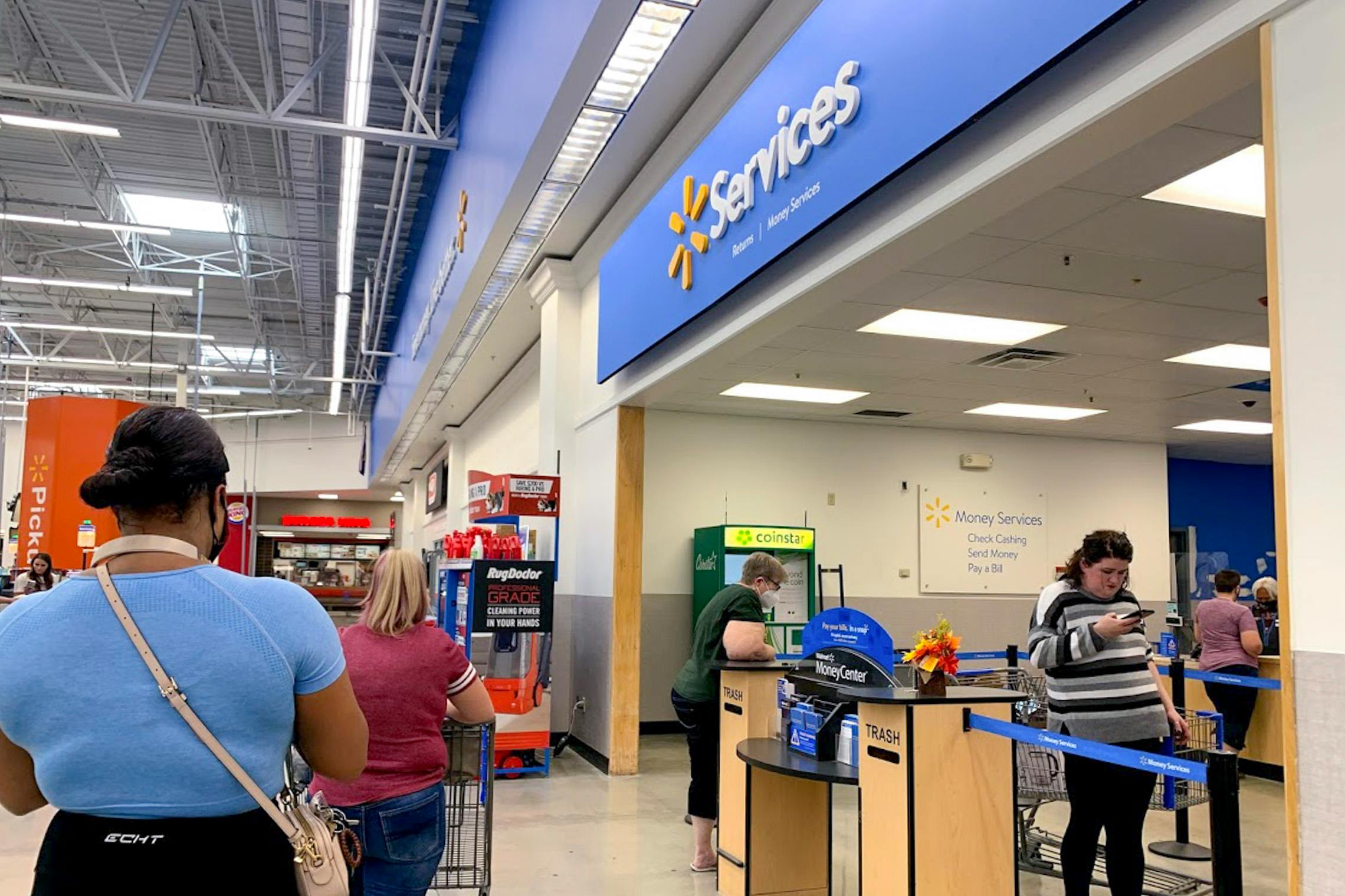 People standing in line for the Services desk in Walmart to return items.