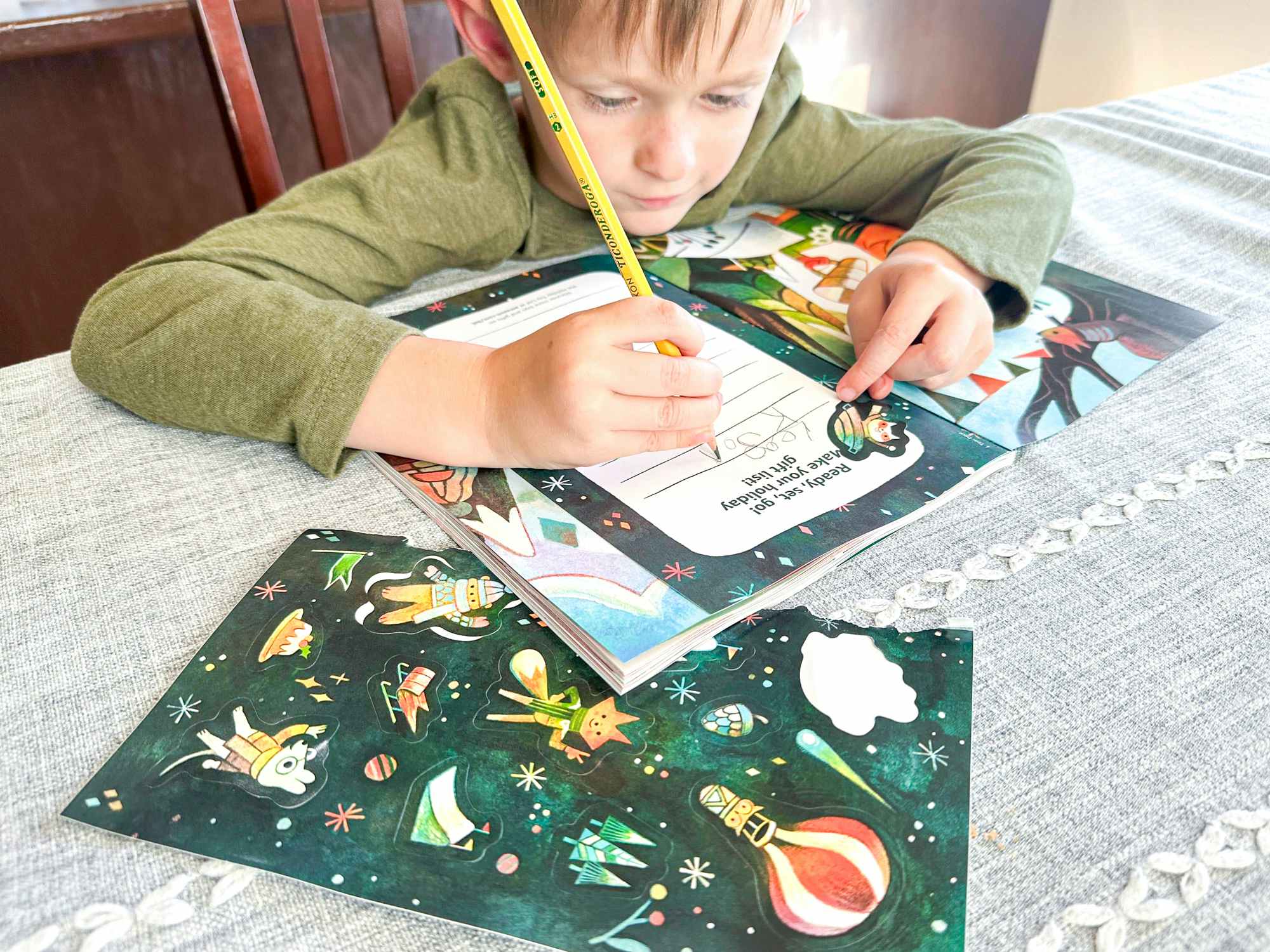 a boy writing a wishlist in the 2023 Amazon toy book