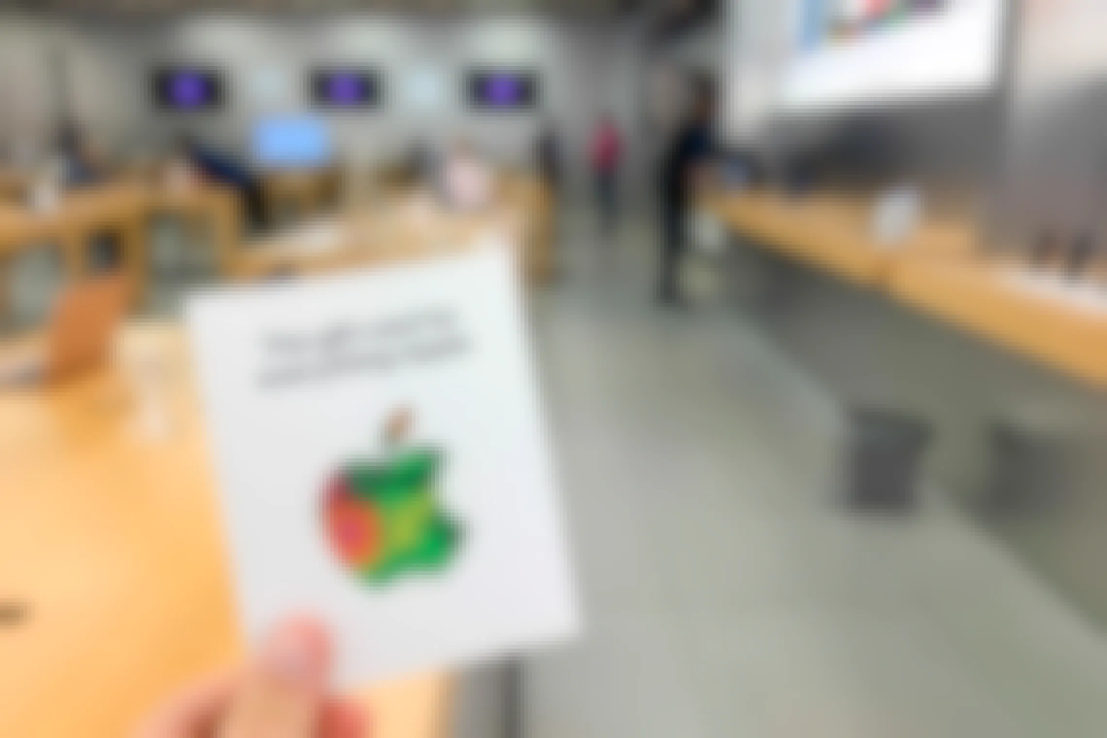 Someone holding up an apple gift card in the apple store