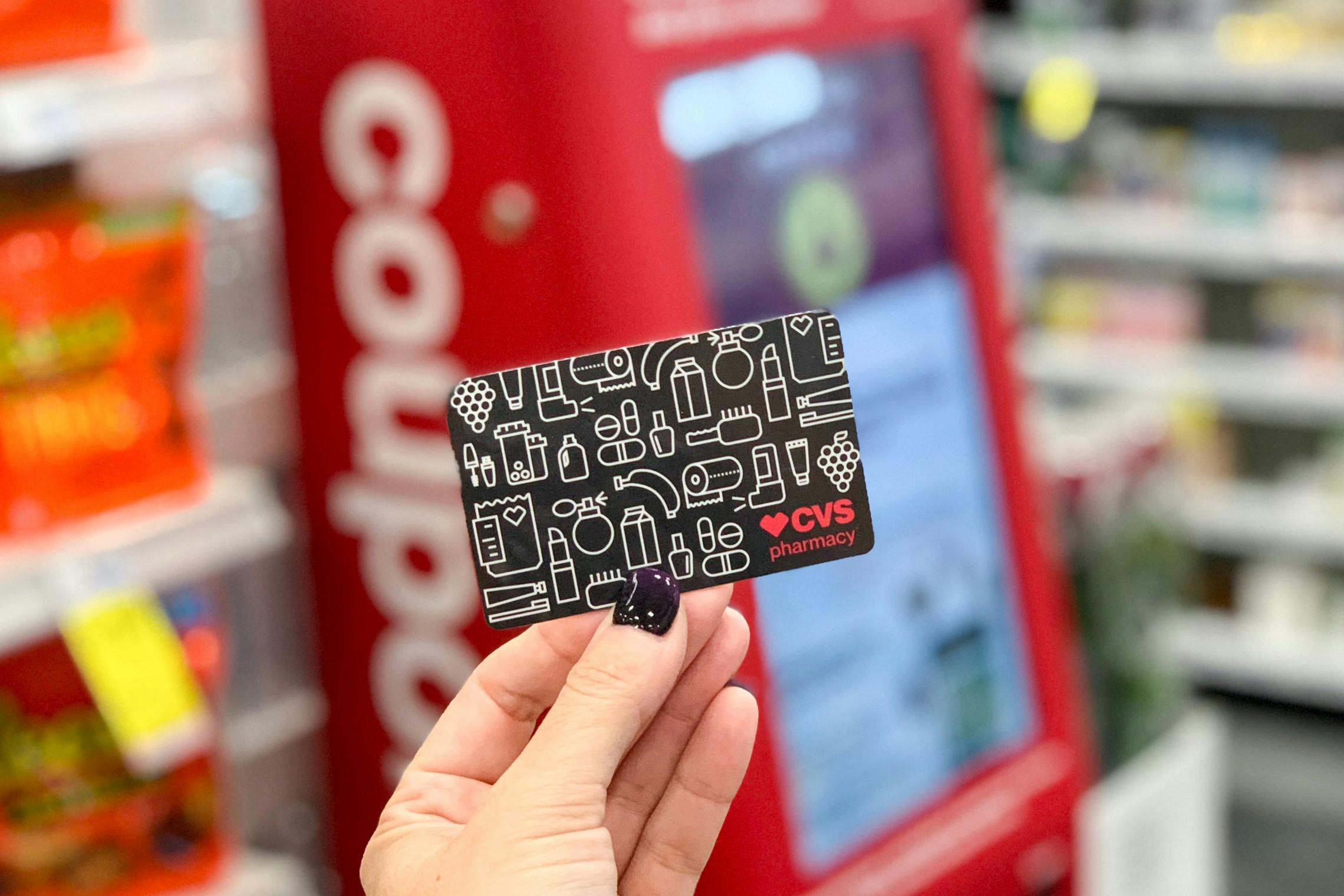 A person holding a CVS gift card in side of CVS
