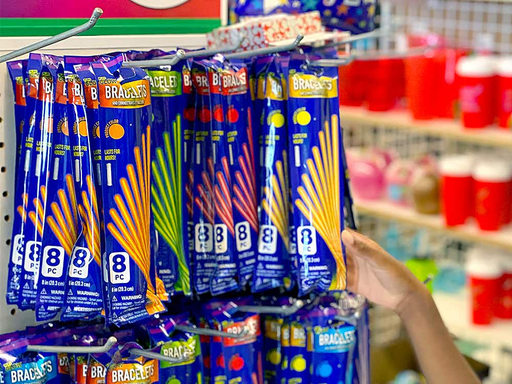 child grabbing glow stick bracelets from dollar tree end cap