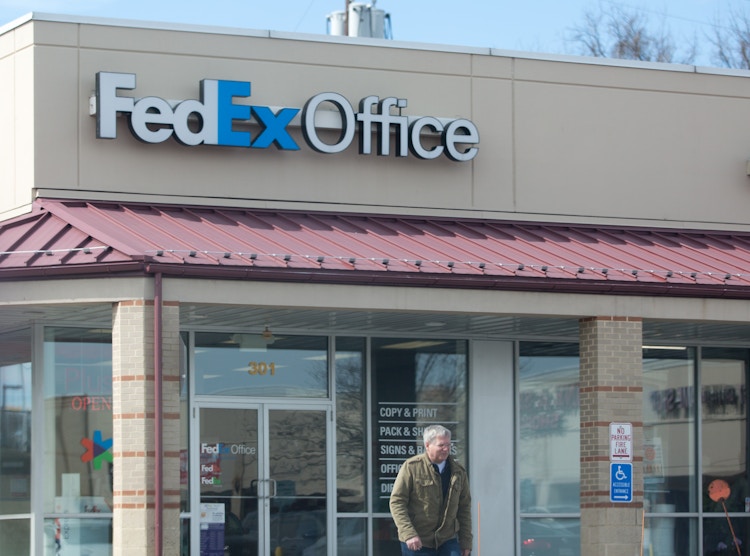 A man exiting a FedEx store.