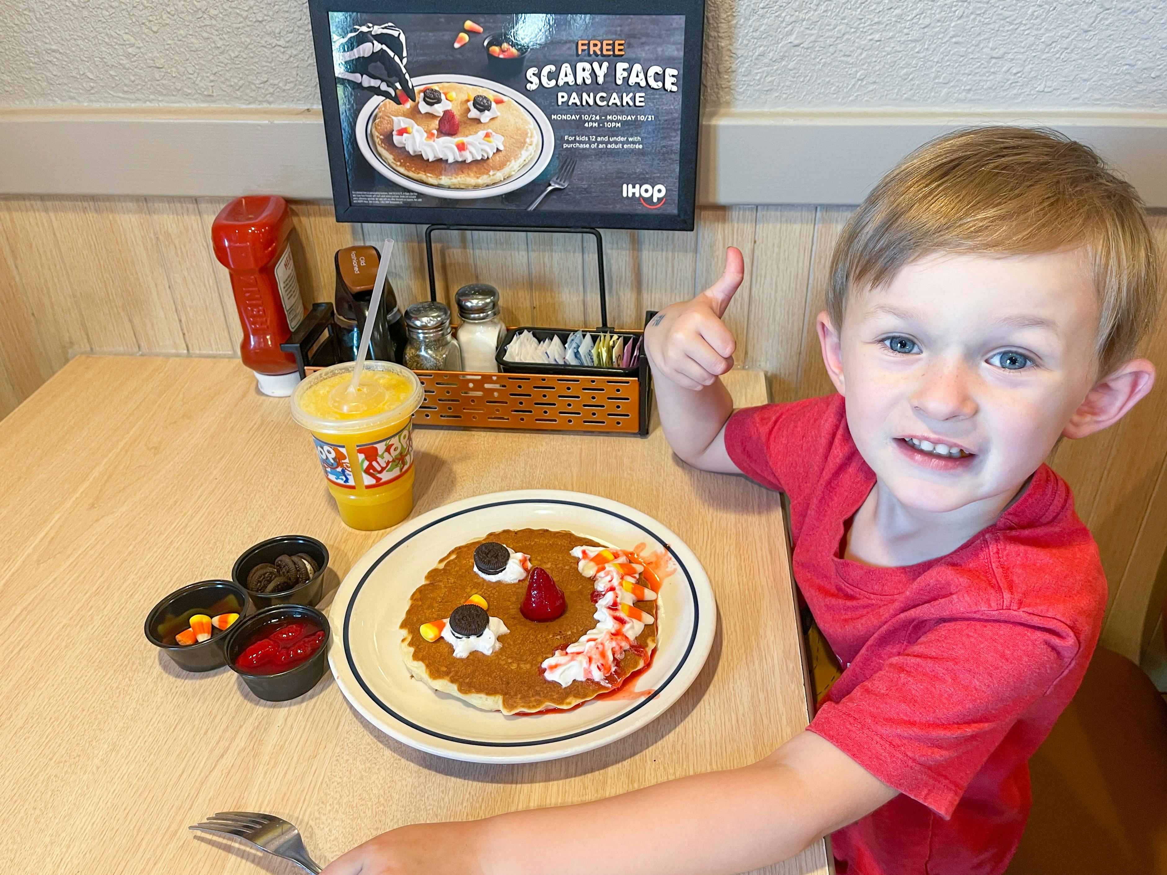 little boy giving thumbs up next to ihop scary face pancakes 