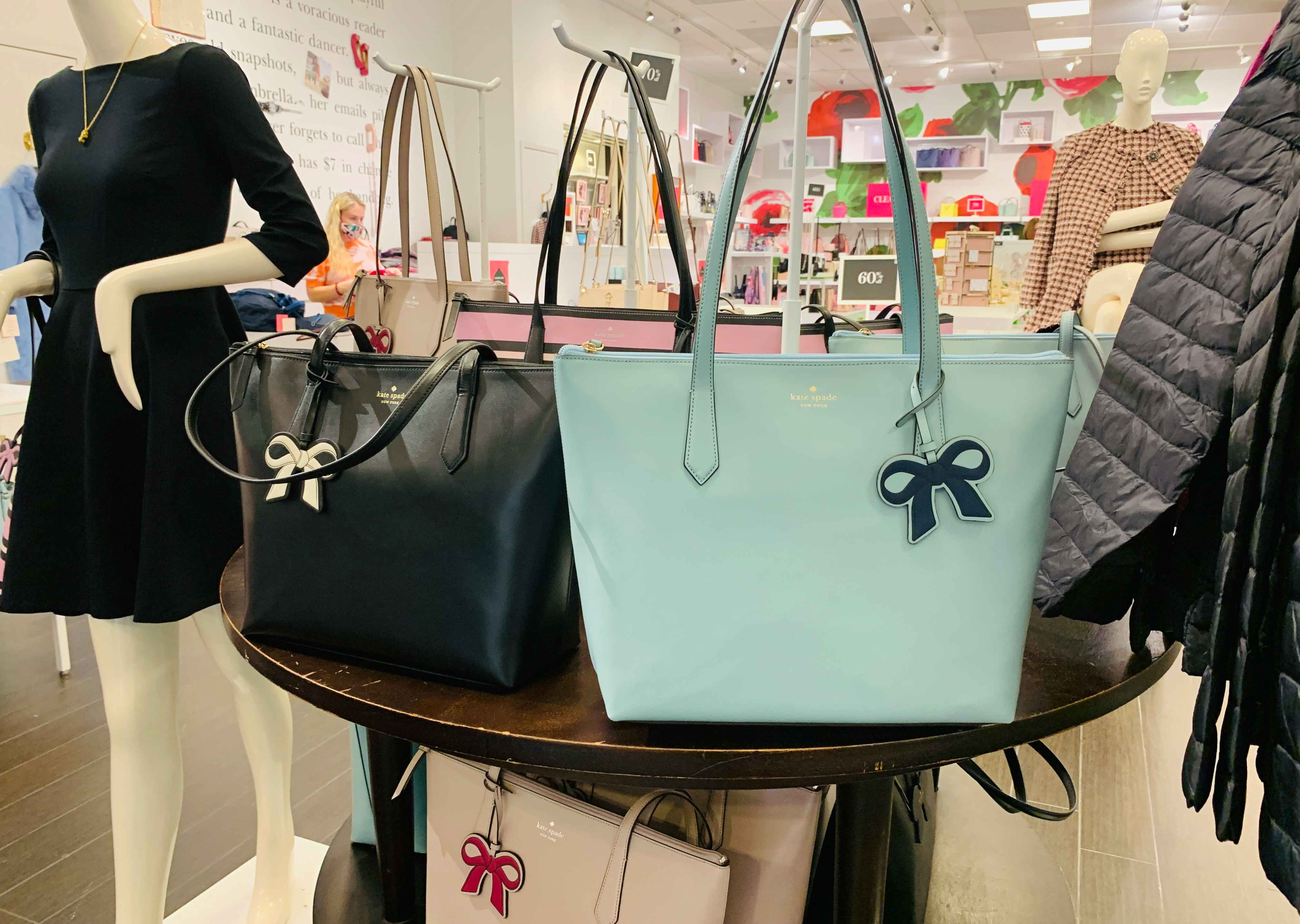 A display of tote bags inside a Kate Spade store.