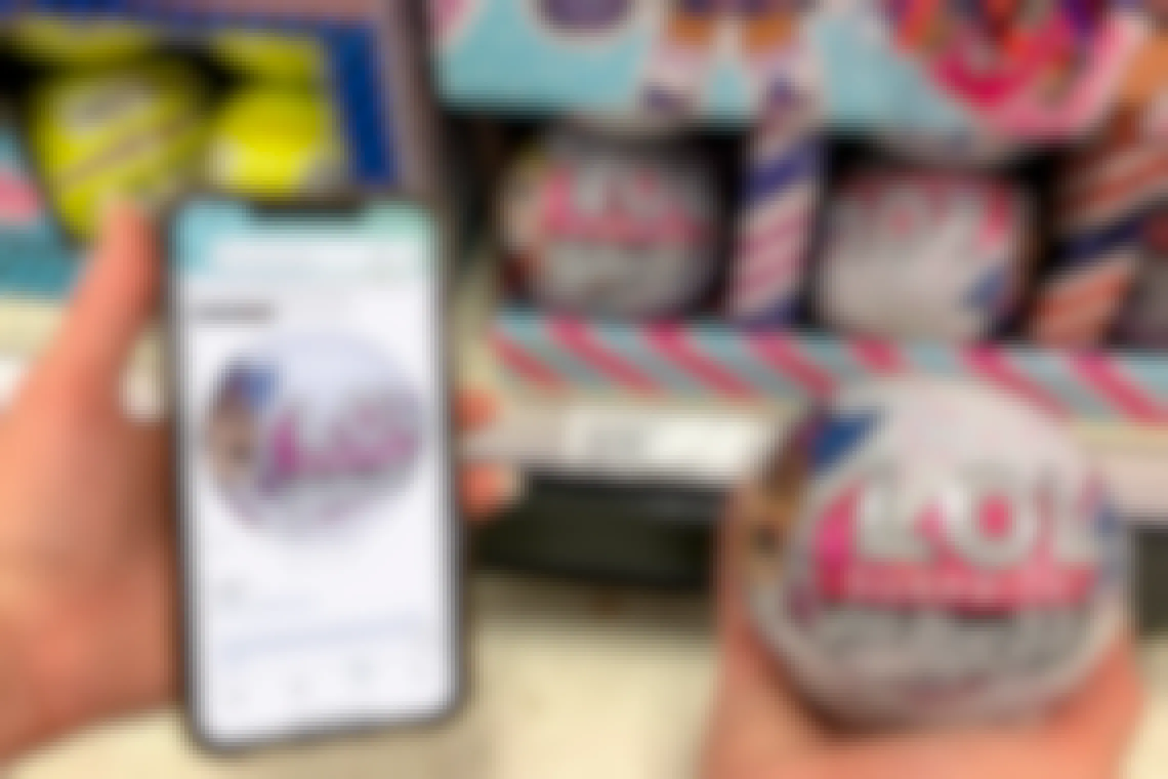 Woman holding up an LOL Surprise all star ball in target doing a price check on her phone using amazon