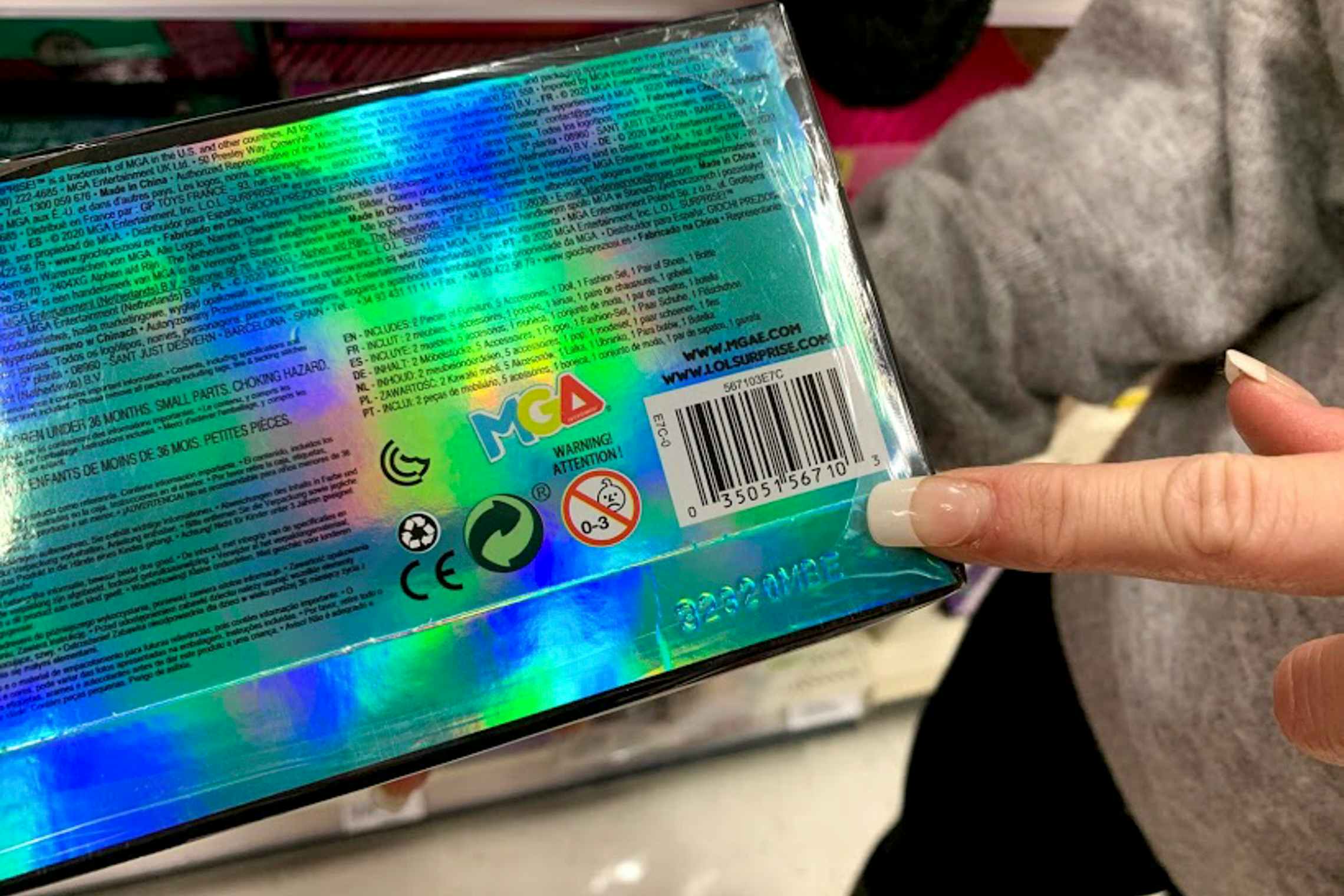 Woman pointing to bar code on lol surprise toy