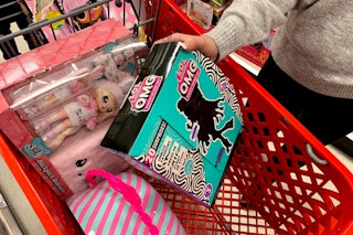 Woman loading her shopping cart at target with LOL Surprise doll toys