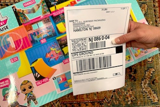 Woman holding shipping label for LOL Surprise toy recycling