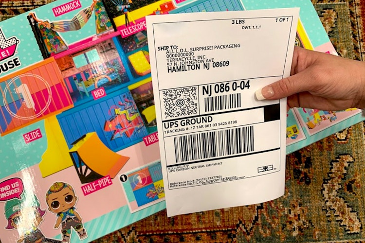Woman holding shipping label for LOL Surprise toy recycling