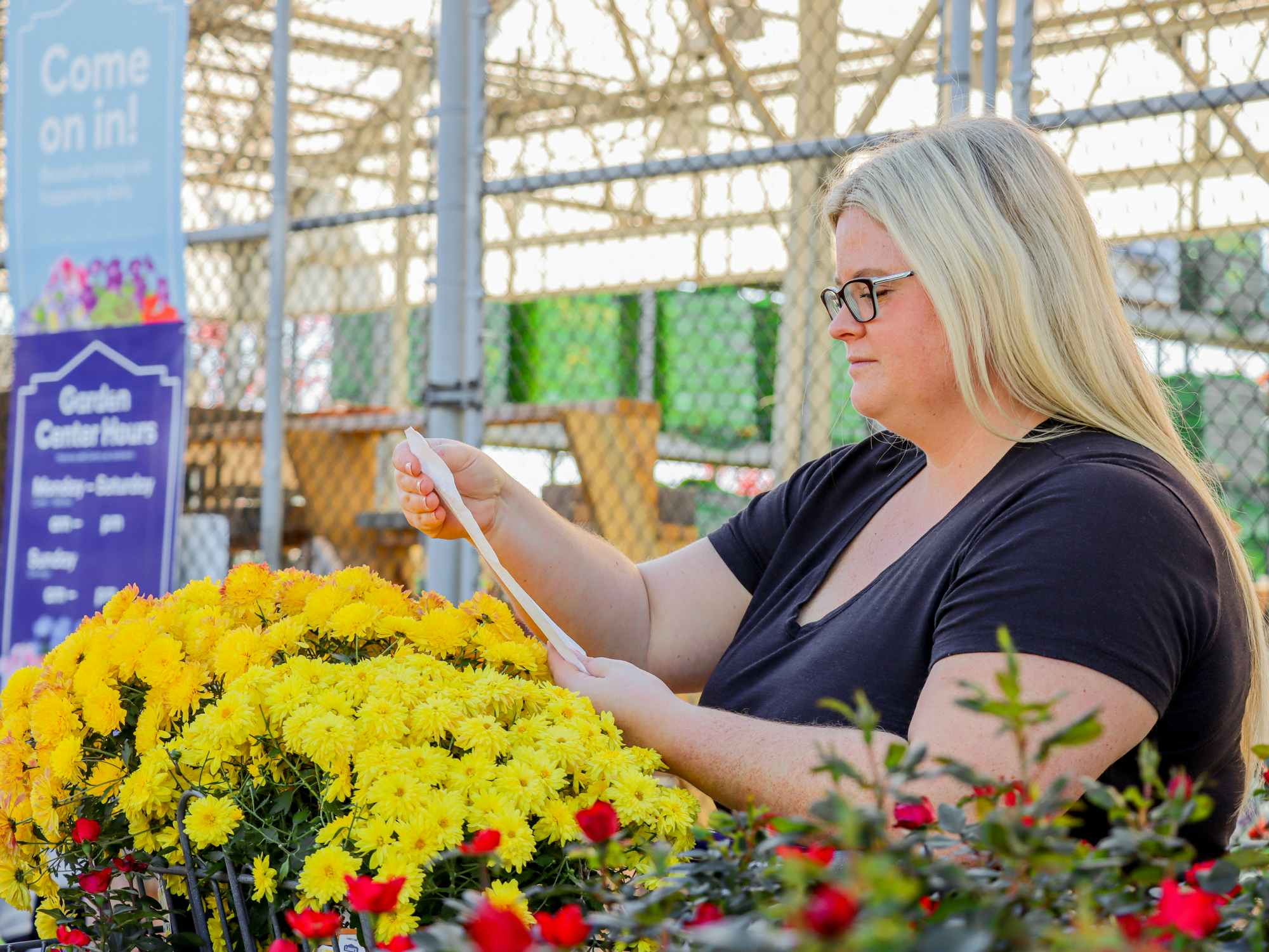 a person looking at a receipt in the plant section of lowes
