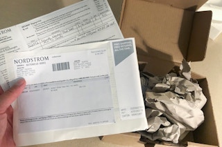Someone holding delivery receipt with delivery box