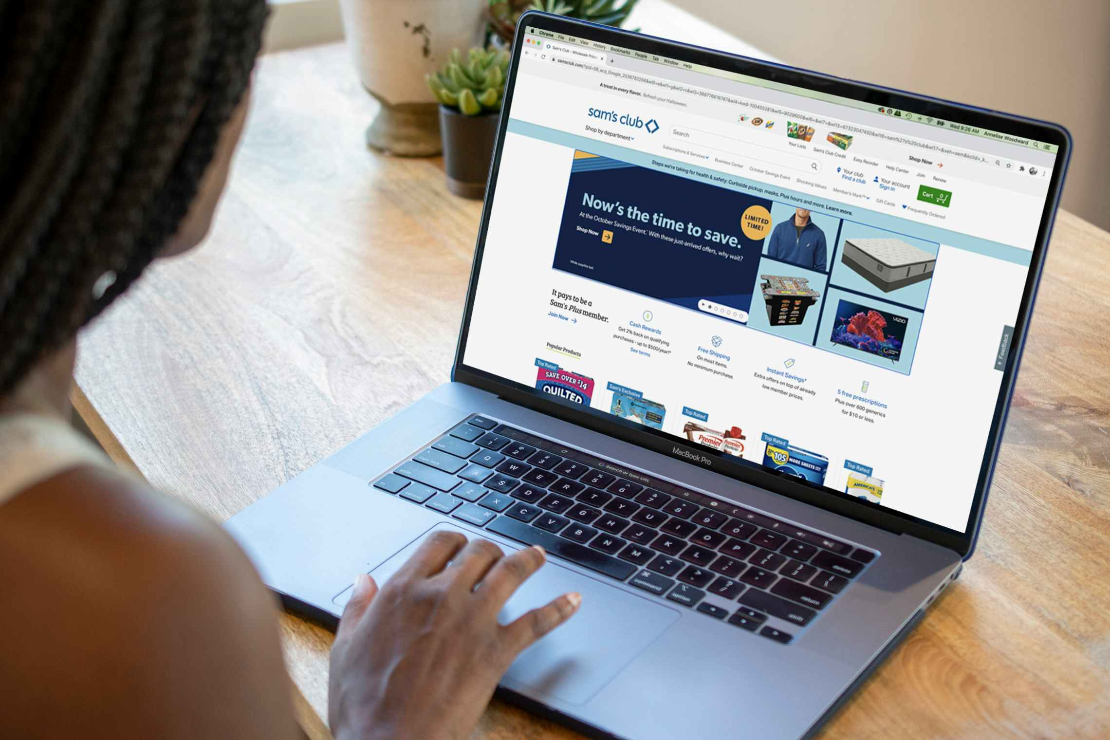 A person using a laptop to look at the Sam's Club website.