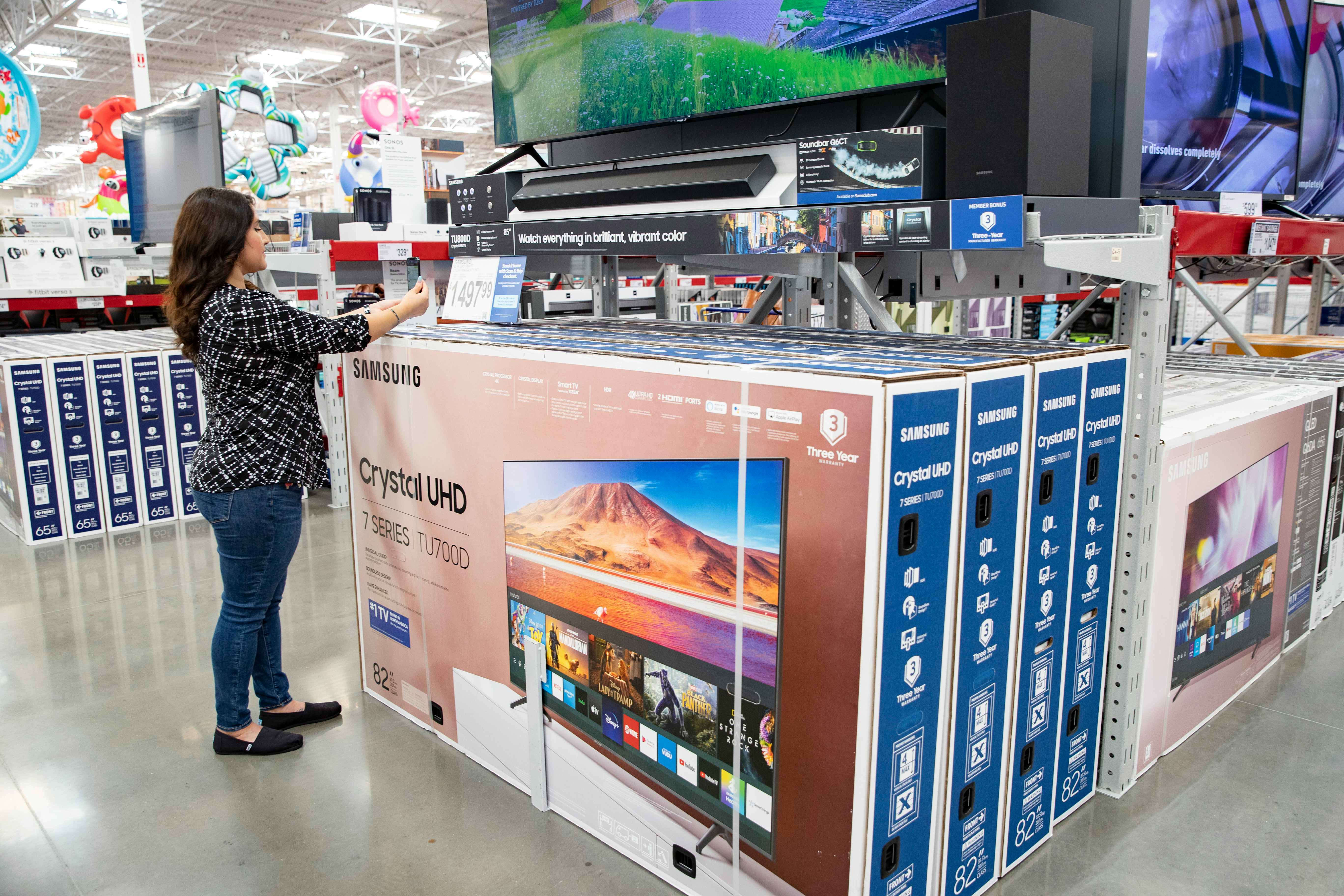 A Sam's Club member shopping for TVs in the electronics section at Sam's Club black friday.