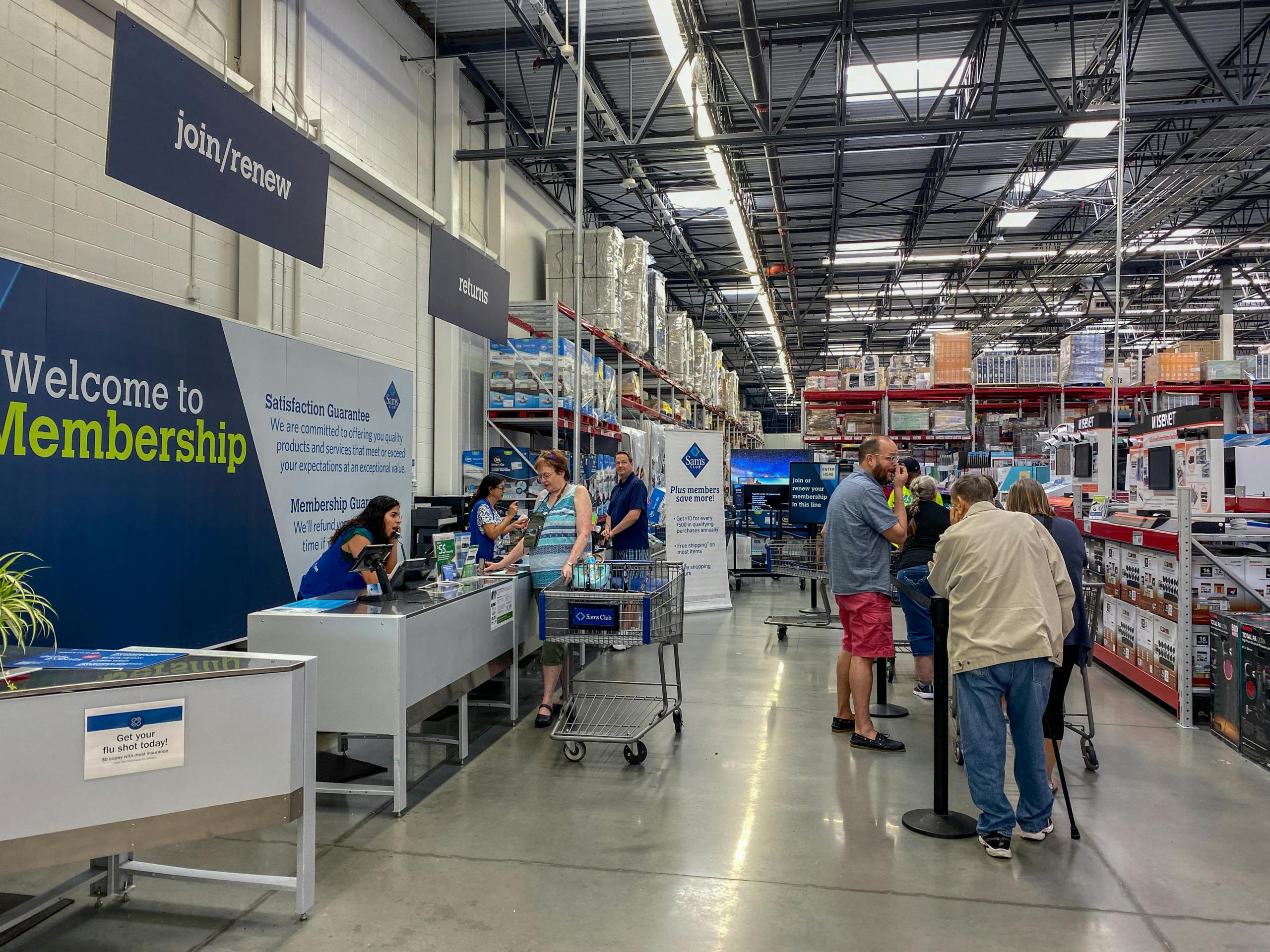 Customers standing in line, waiting to be helped at Sam's Club Customer service and returns counter.