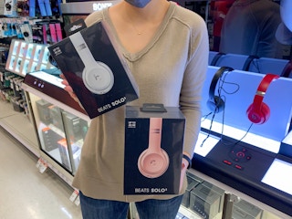 A woman holding Beats headphones