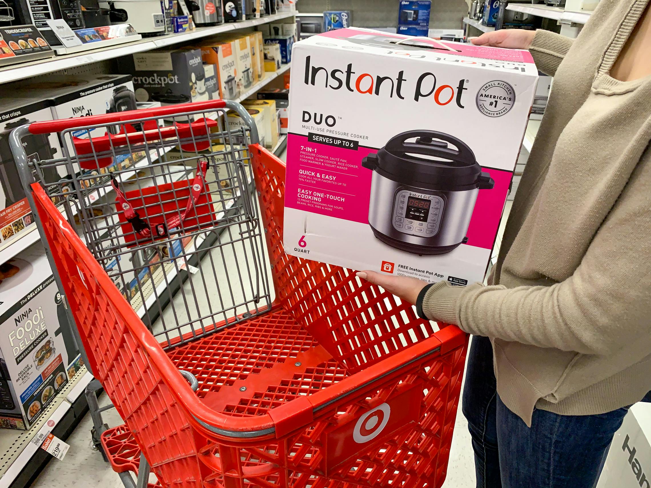 a woman putting an Instant Pot into her Target cart at the store