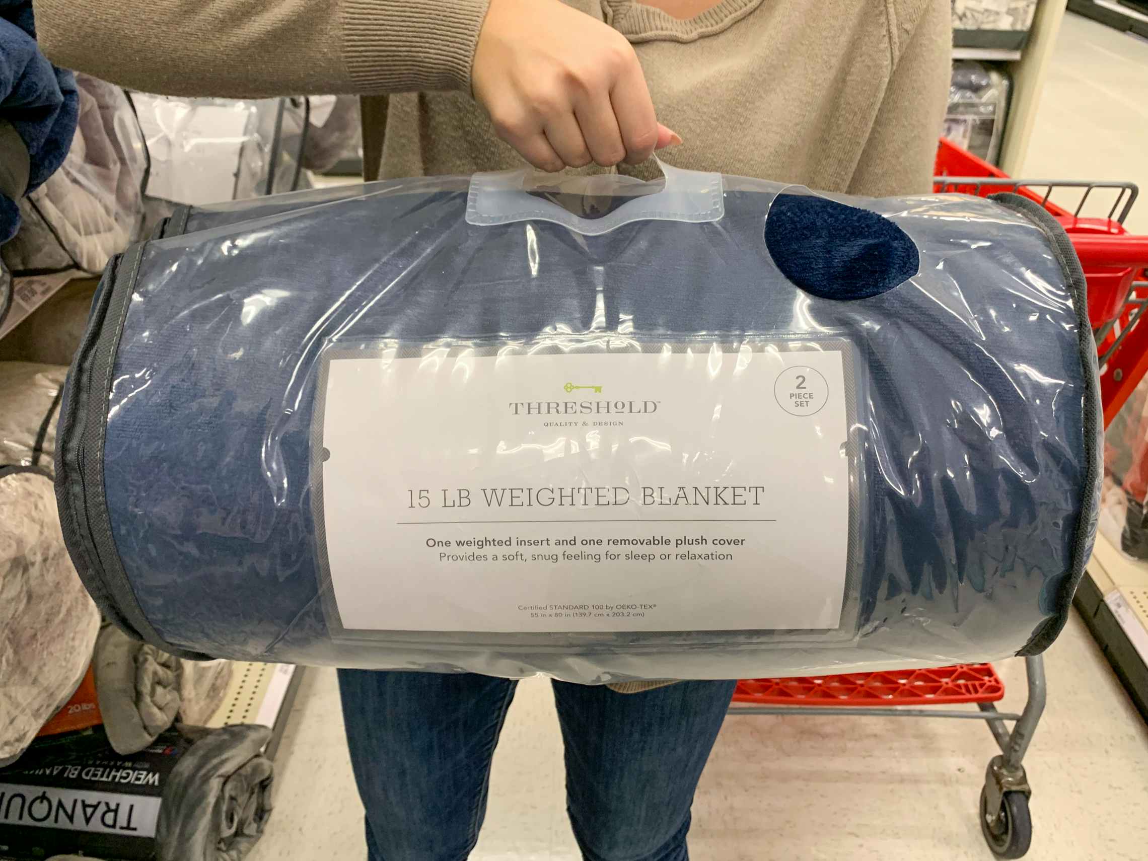 A woman holding a blue weighted blanket