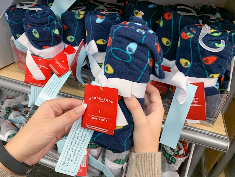 A person's hand picking out a pair of rolled-up Wondershop pajama pants from a shelf at Target.