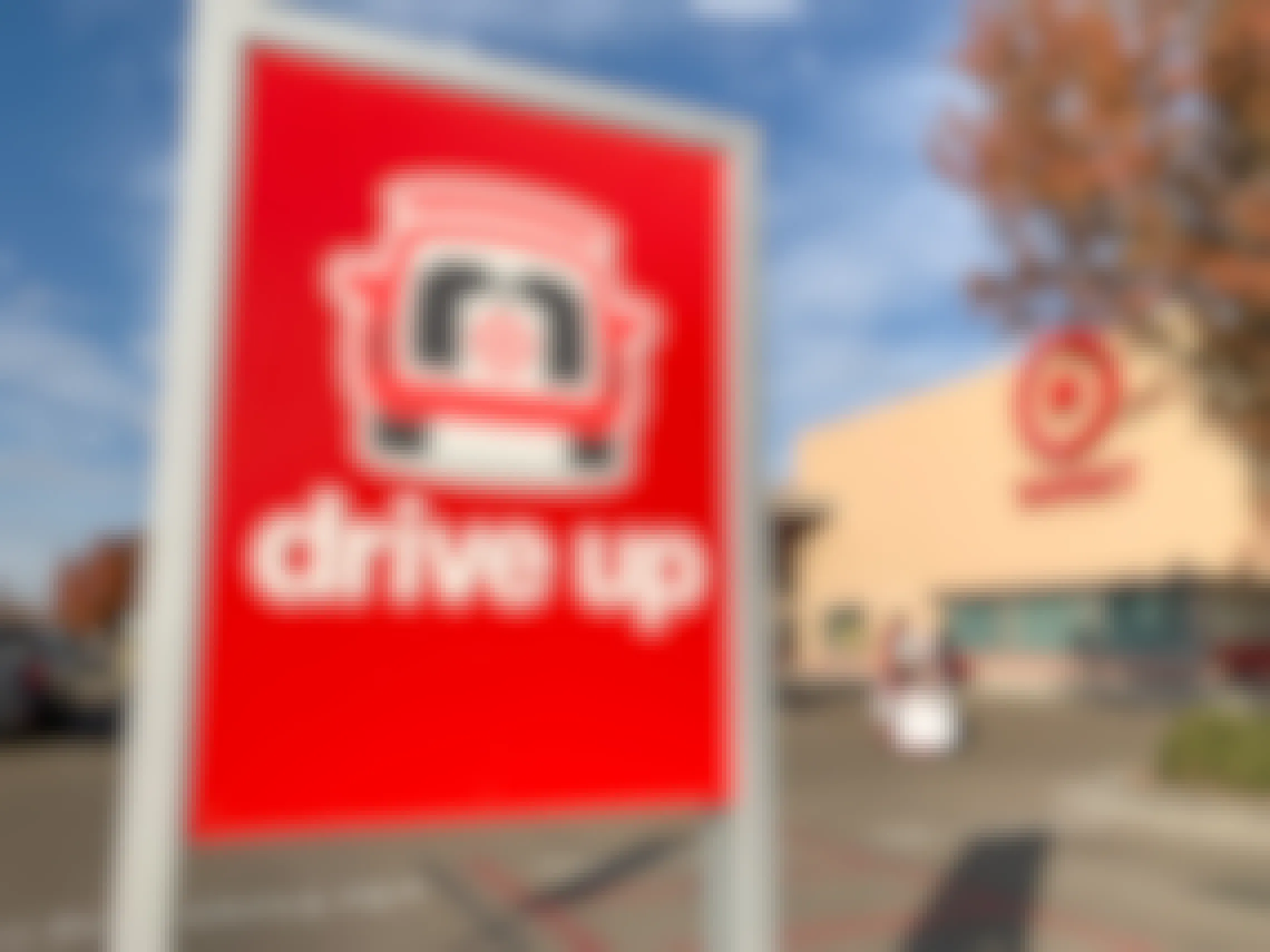 The Target Drive Up sign in the parking lot in front of a Target storefront.