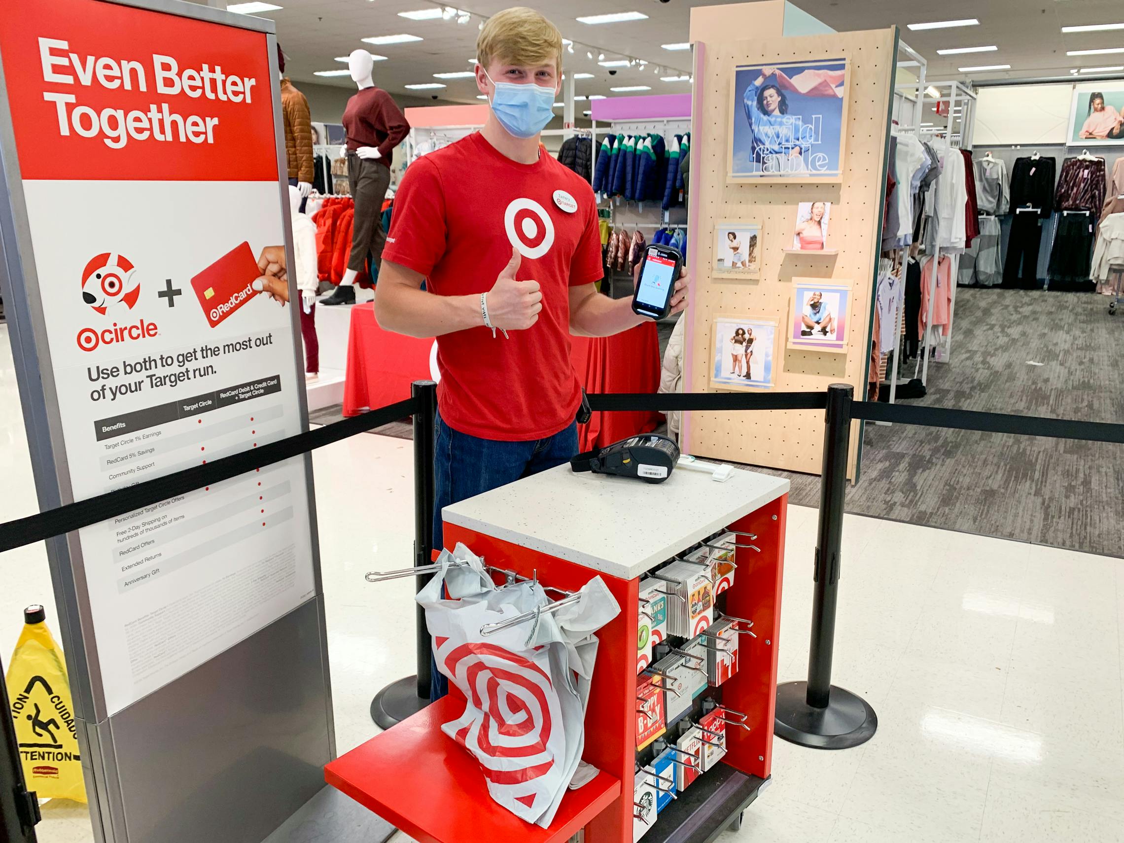 An employee standing at a small checkout stand on the sales floor at Target.