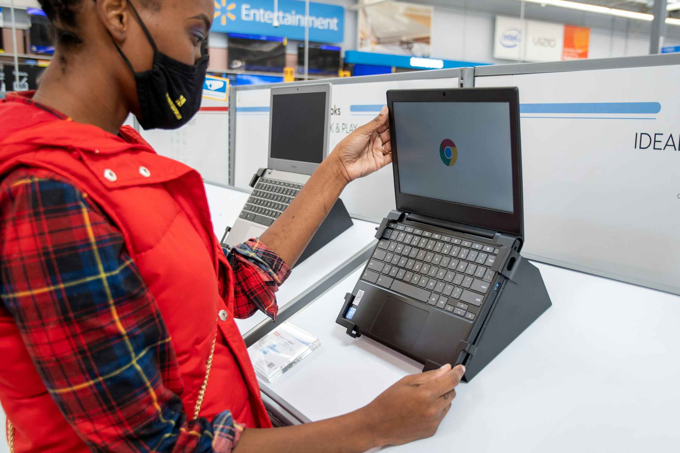 A woman looking at Chromebook laptop computers at Walmart