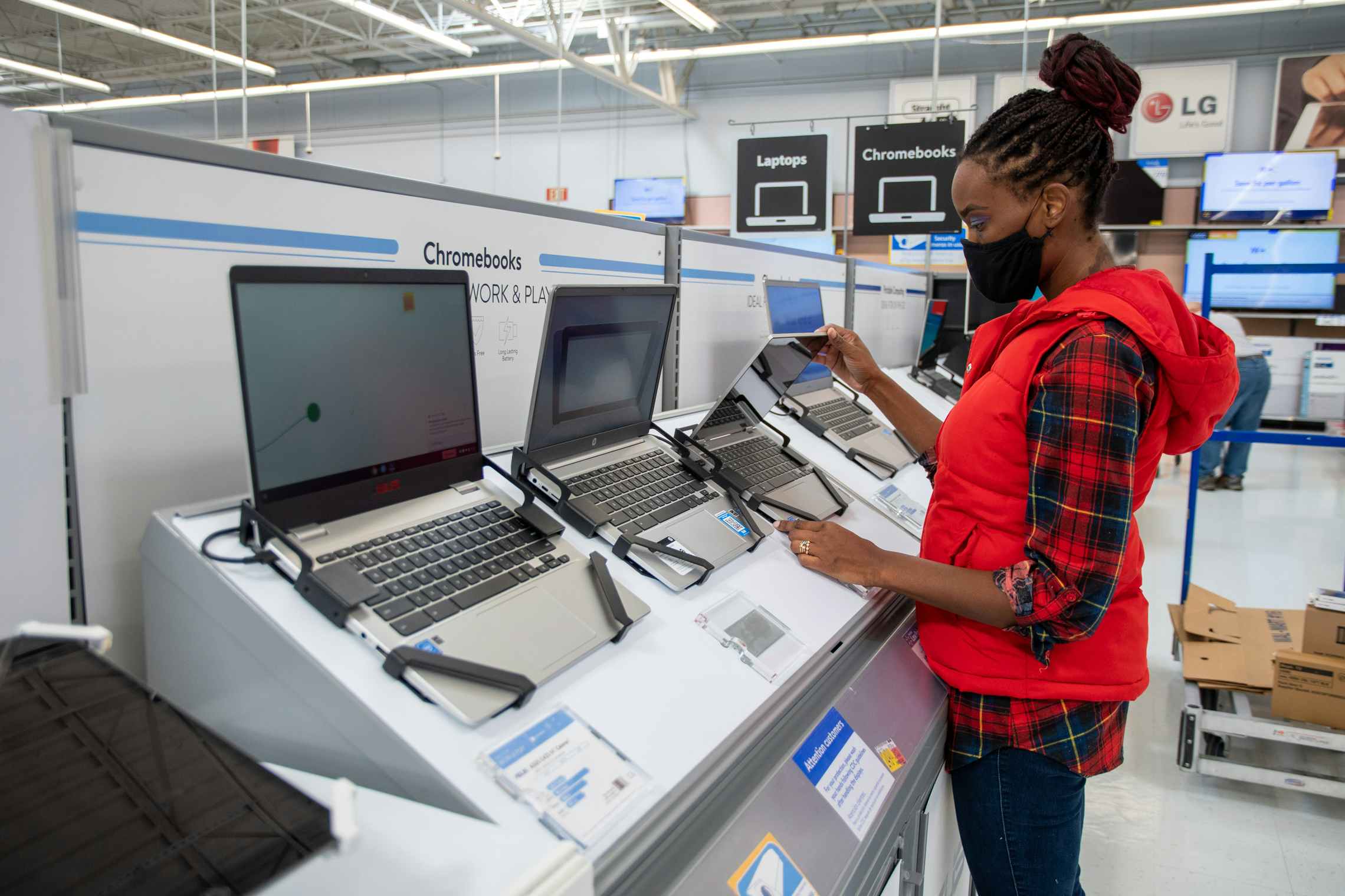 A woman looking at Chromebook laptop computers at Walmart