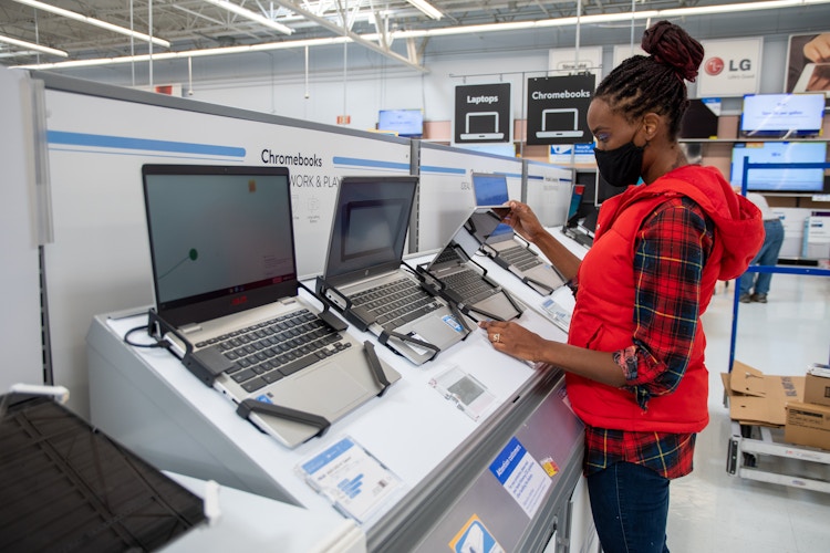 A woman looking at Chromebook laptop computers at Walmart
