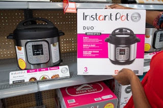 person taking instant pot box off shelf at walmart
