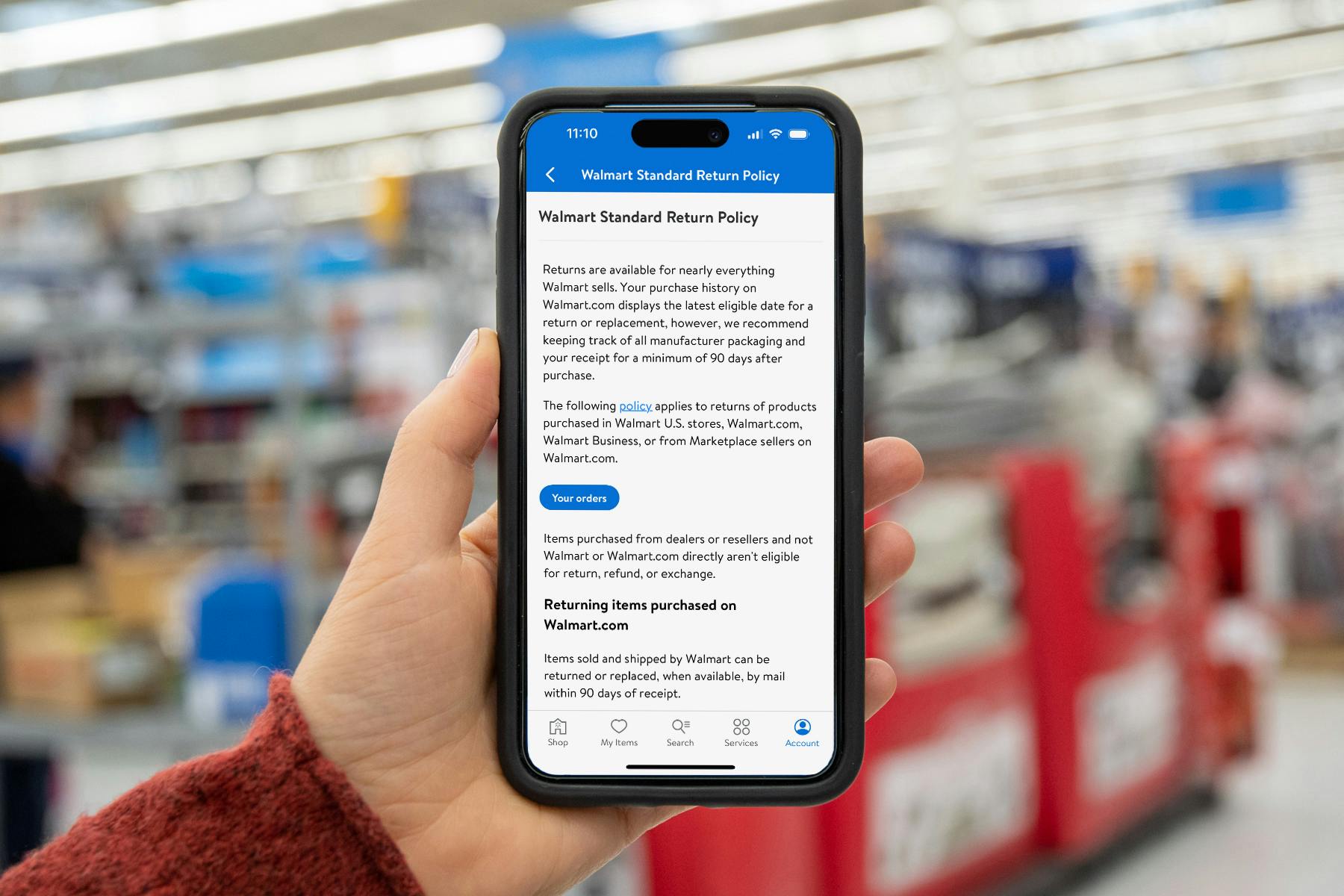 Someone holding up a phone displaying the Walmart return policy