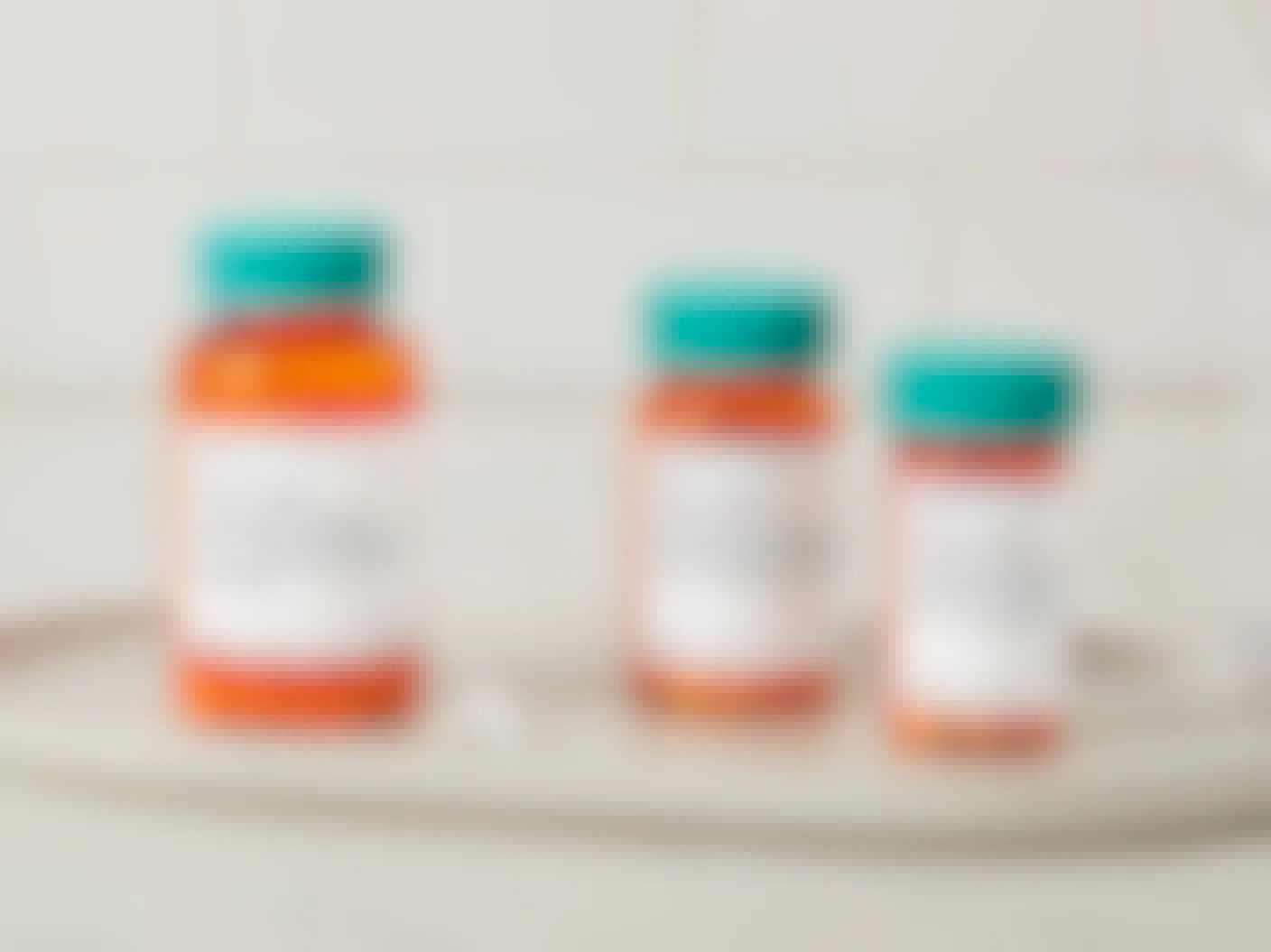 Three Amazon Pharmacy Rx pill bottles sitting on a tray on a bathroom counter.