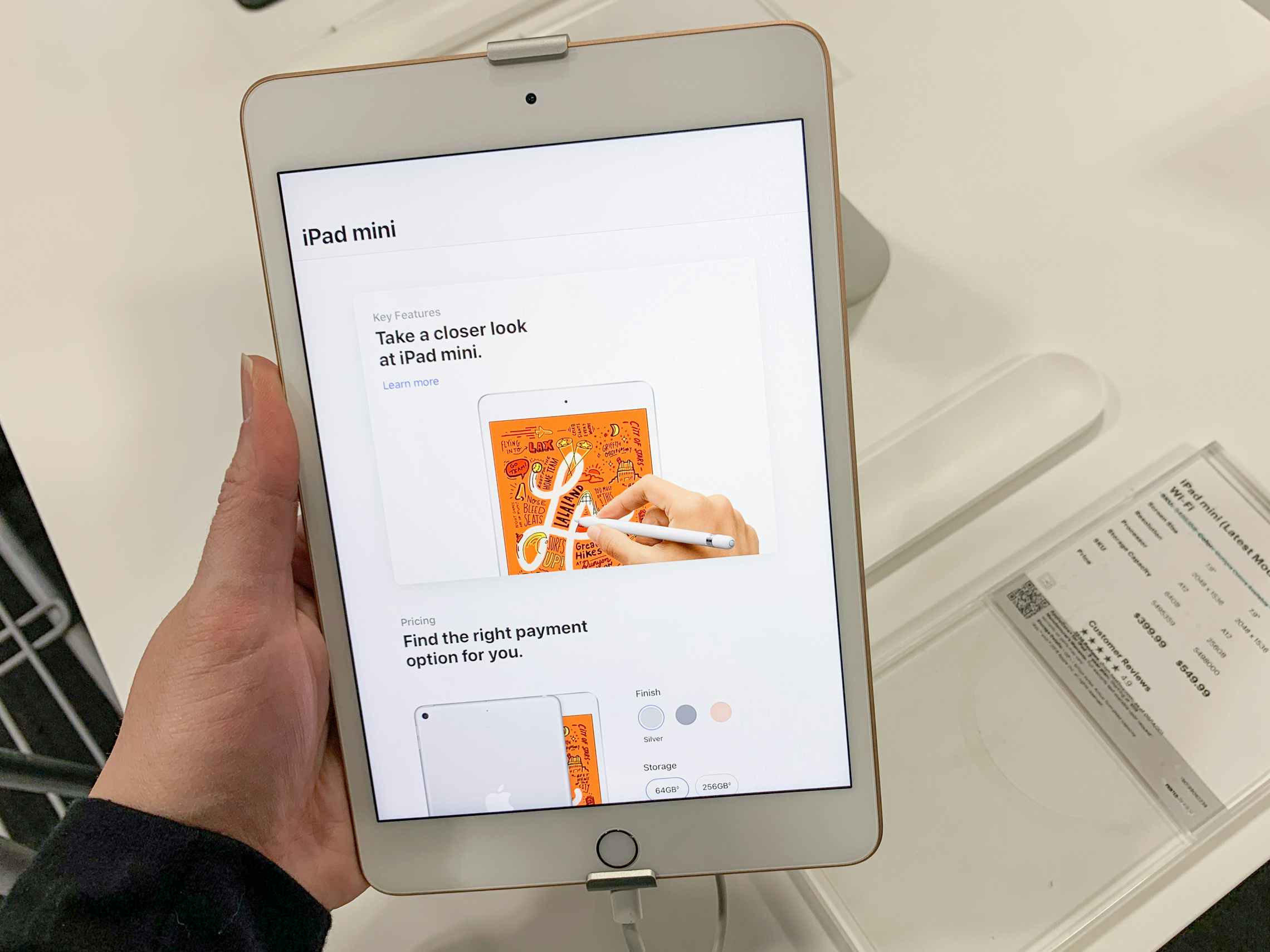 a hand holding an apple ipad mini on display at best buy