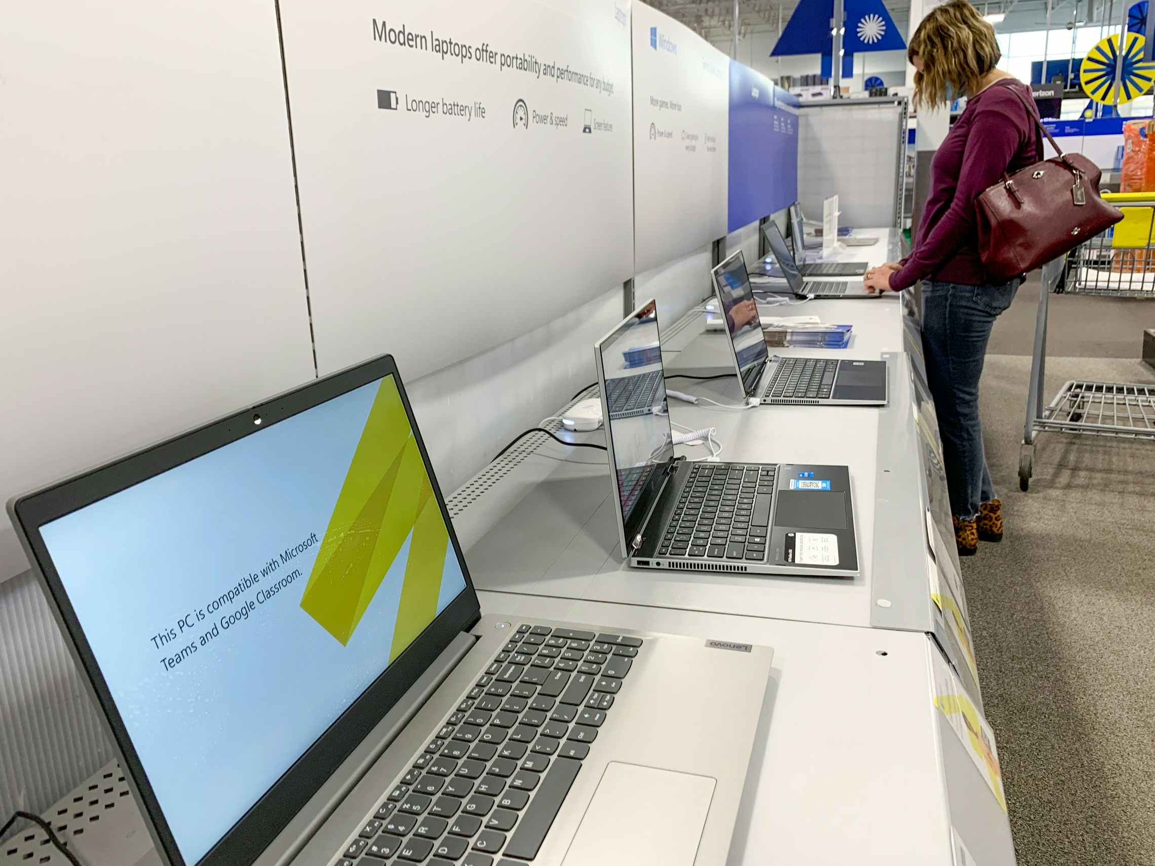 A person looking at the laptops on display at Best Buy