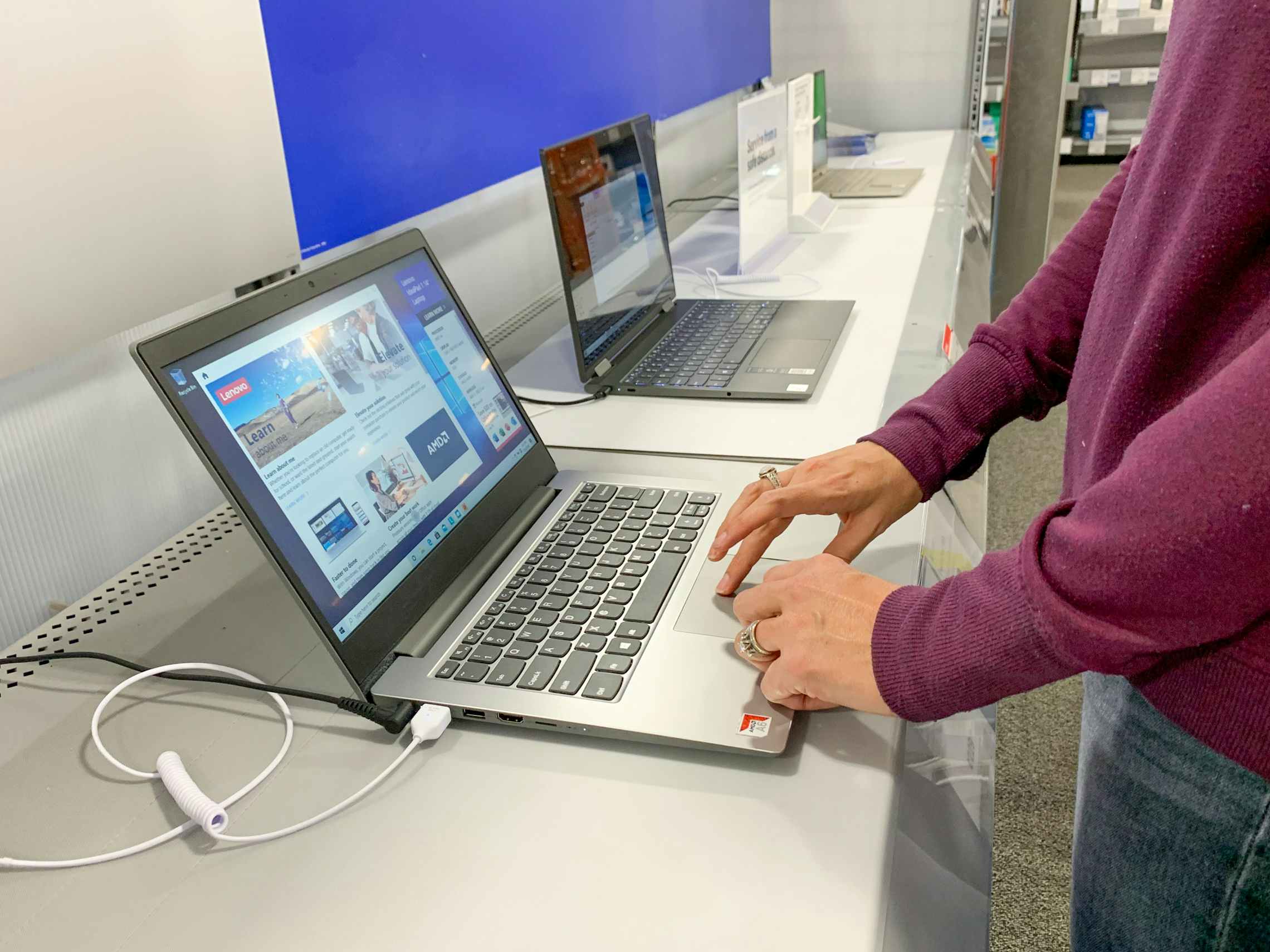 Someone trying out a laptop on display in store at Best Buy