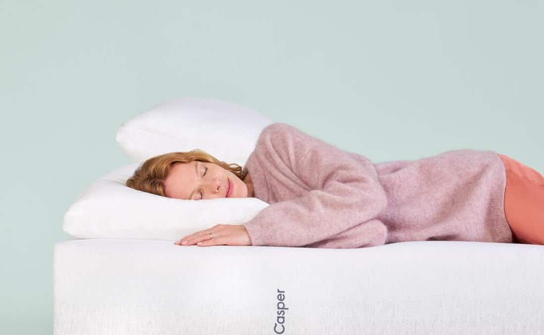 Woman lying on a Casper mattress and pillow