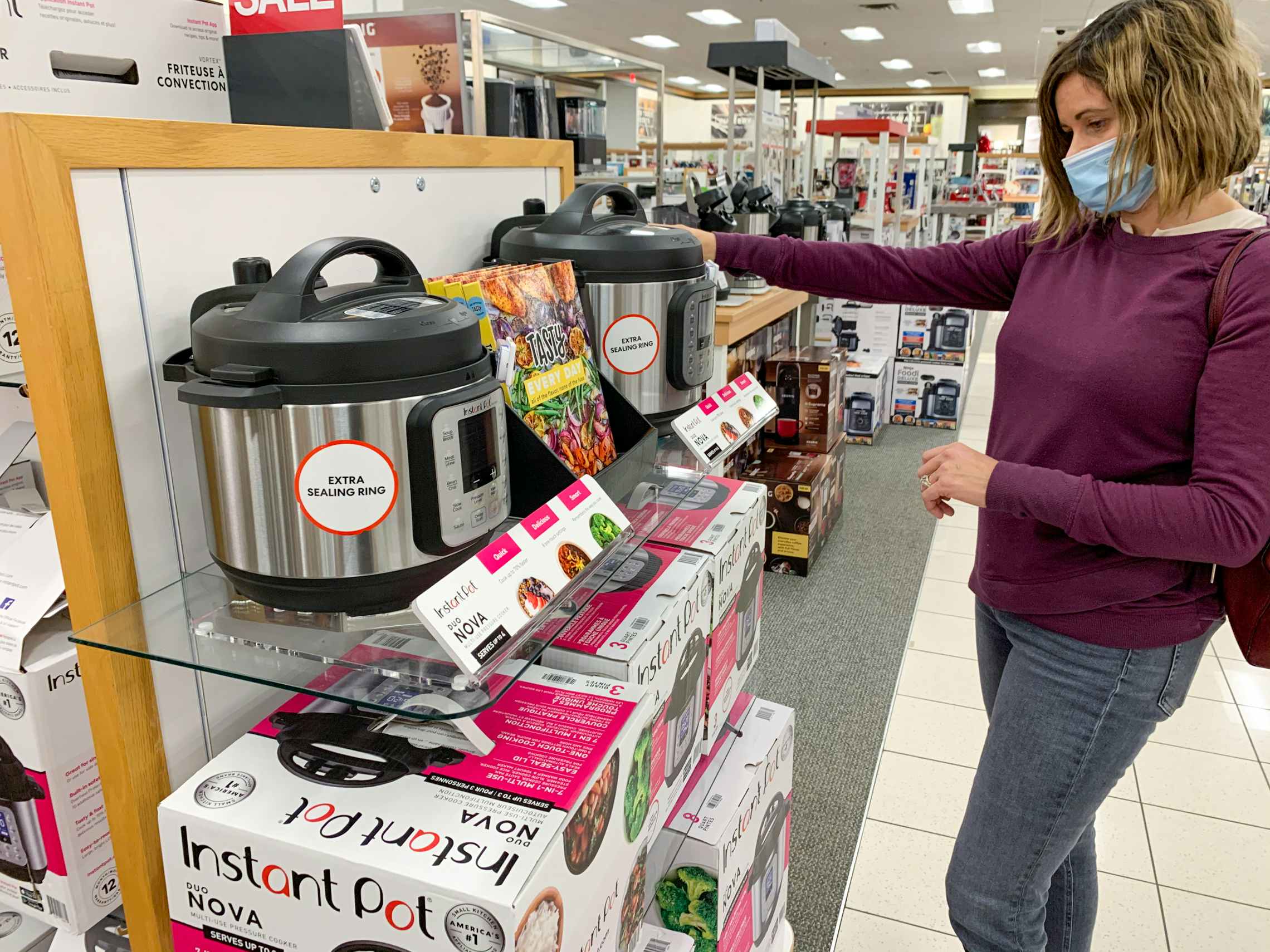 woman in mask looks at instant pots at kohls during black friday