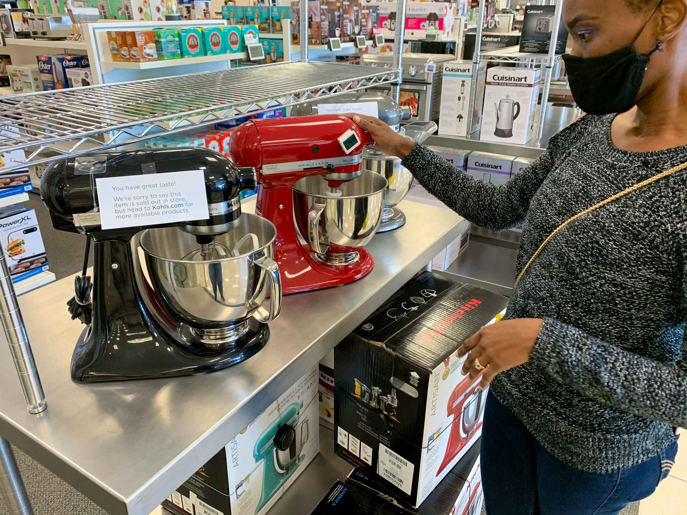 A woman looking at KitcheAid stand mixers