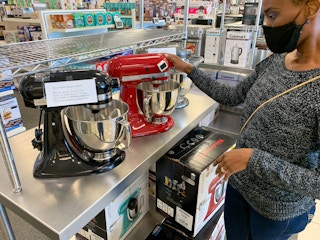 A woman looking at KitcheAid stand mixers