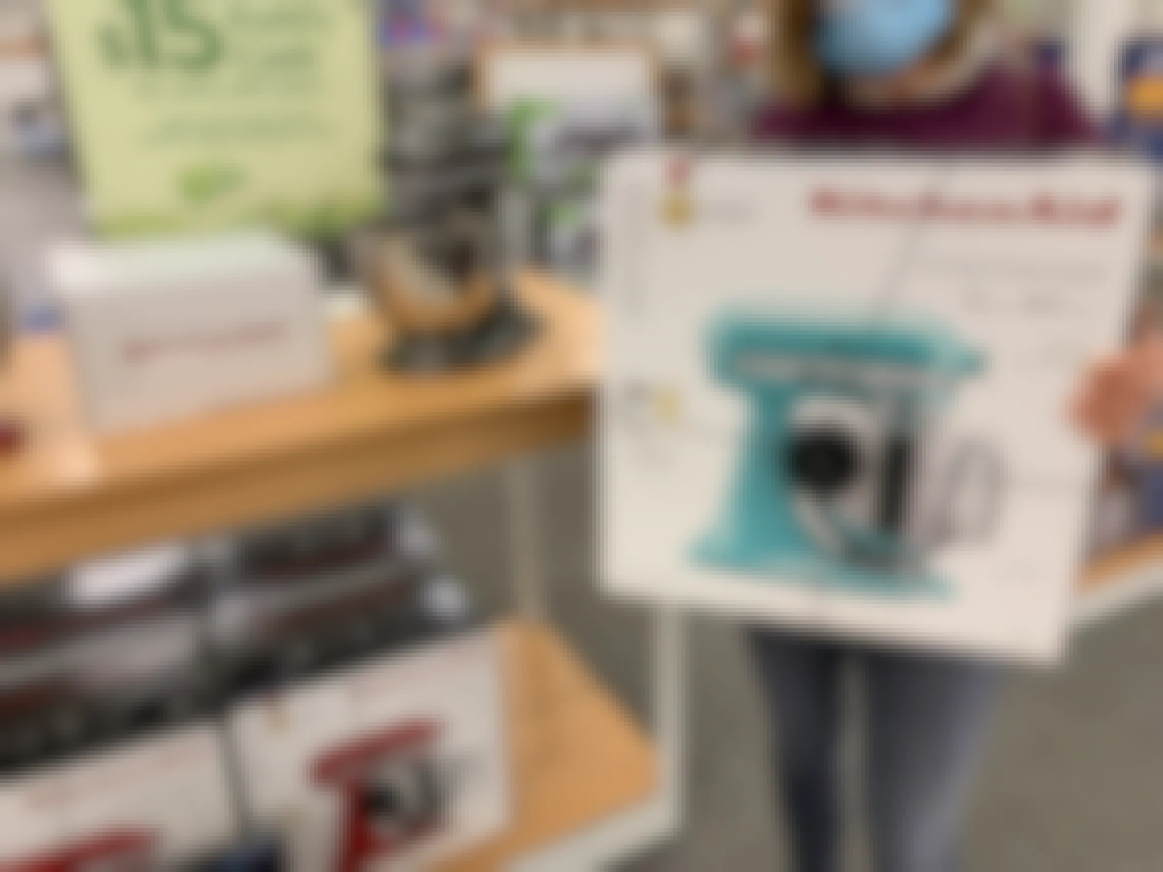 someone holding a kitchenaid stand mixer in front of a kohls cash holiday shopping sign at kohls