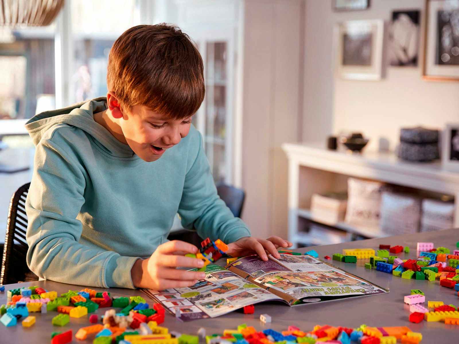 a child looking at a lego life magazine 