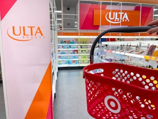 a target hand basket being held in front of ulta sign in the ulta section inside target