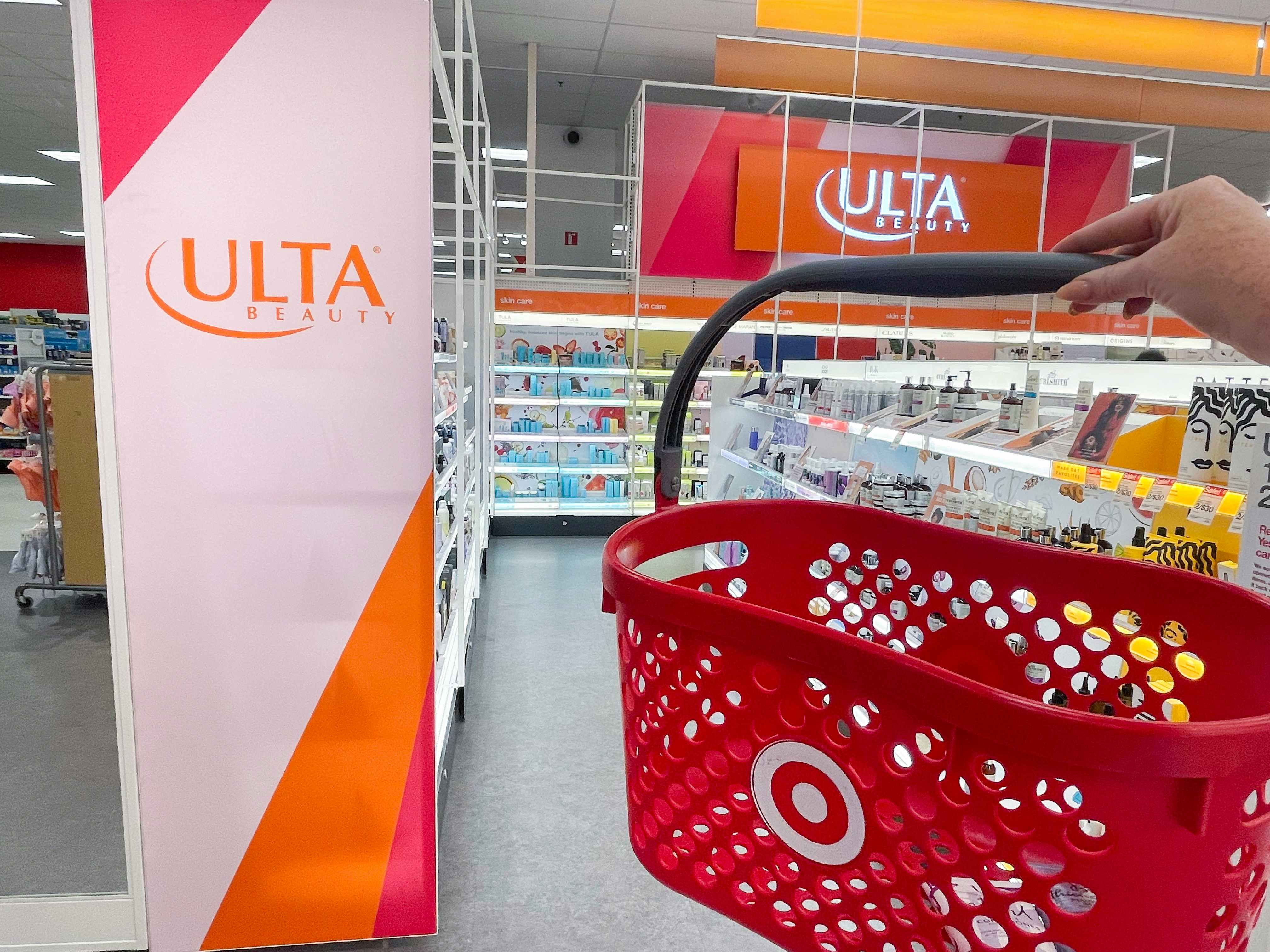 a target hand basket being held in front of ulta sign in the ulta section inside target 