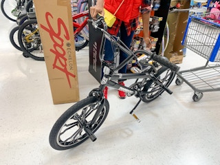 A woman standing next to a Sport Bike inside Walmart