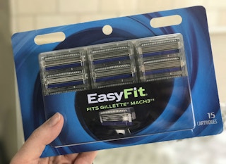 A person holding a pack of Amazon Easy Fit generic razor refills