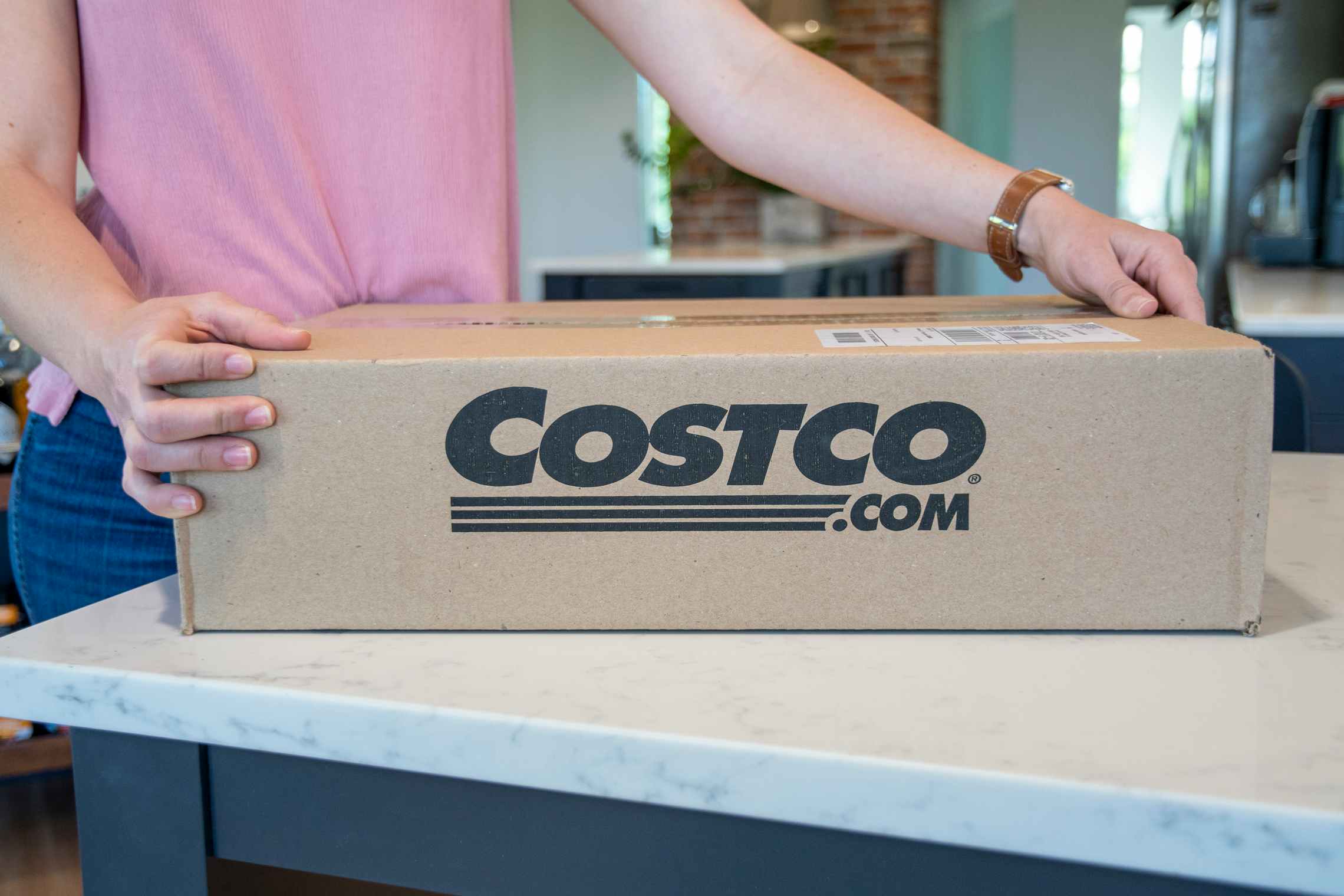 A person opening a Costco.com online order box.