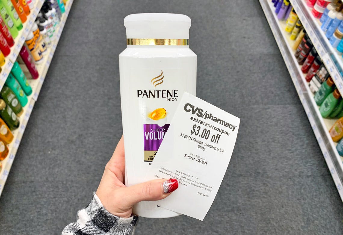 someone holding pantene and coupon at cvs