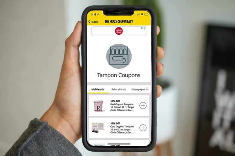 woman holding phone with kcl app open to tampons coupon section